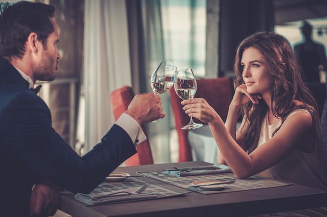Couple frappant des verres à vin au restaurant.